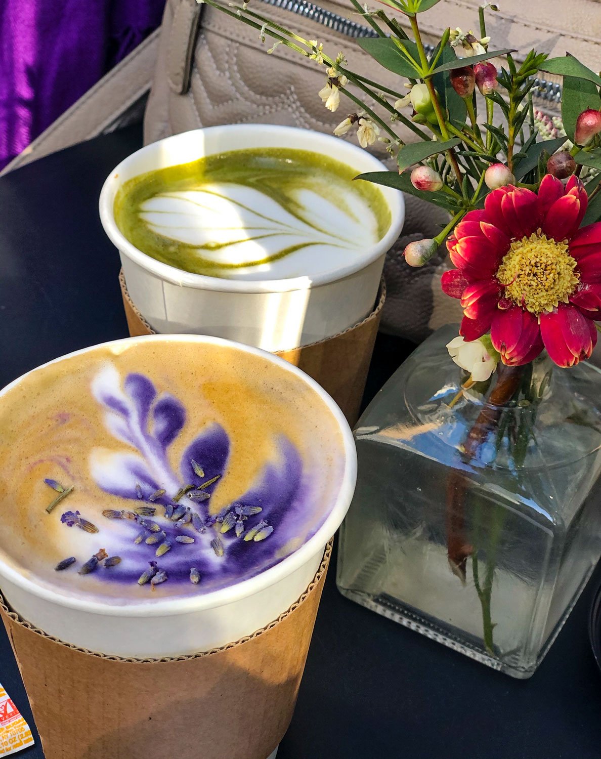 lavender and matcha lattes with flowers on cafe table