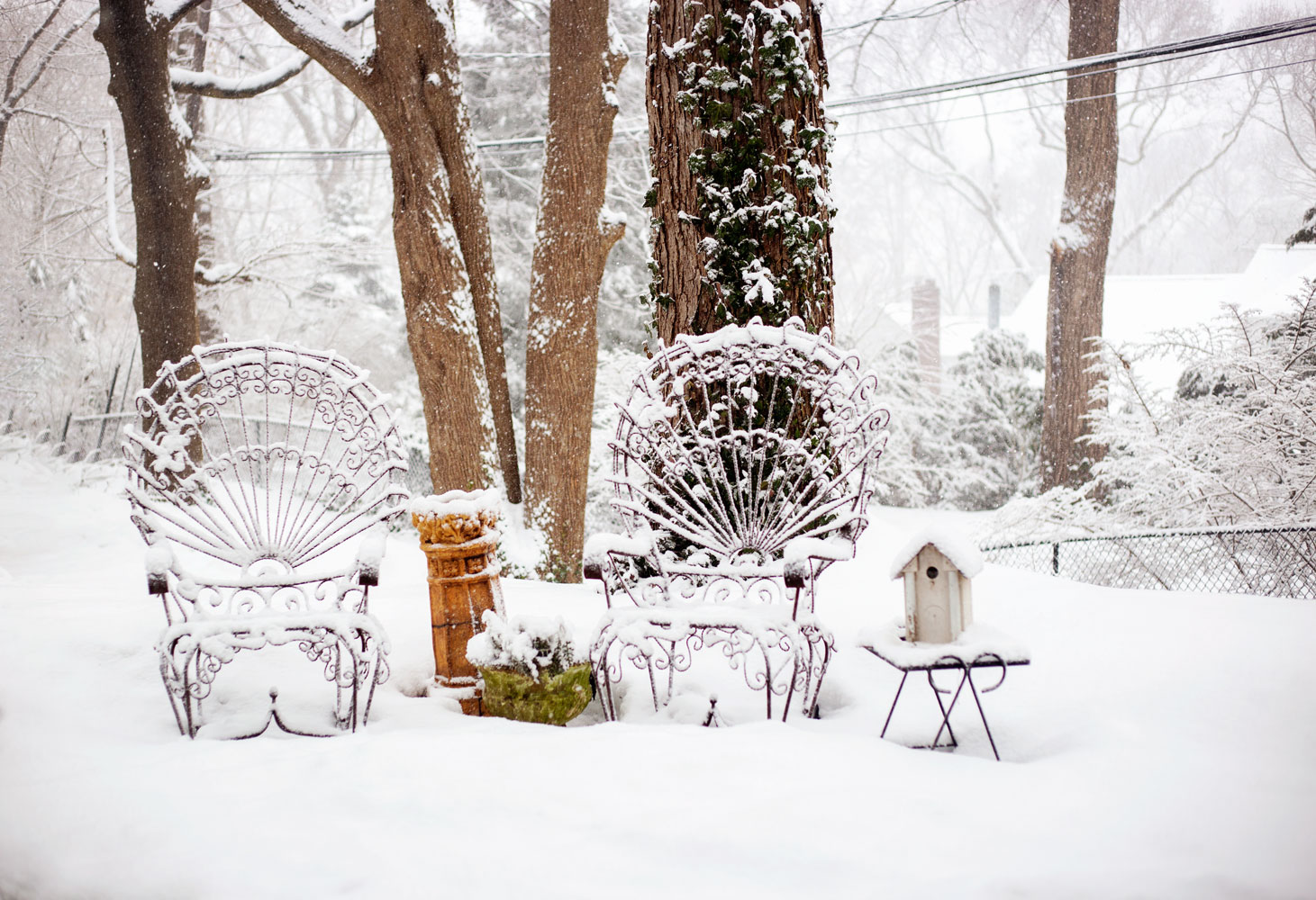 falling snow on antique wrought iron chairs