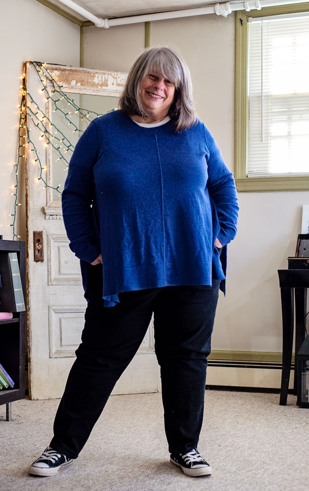 betty standing in living room in cobalt blue sweater