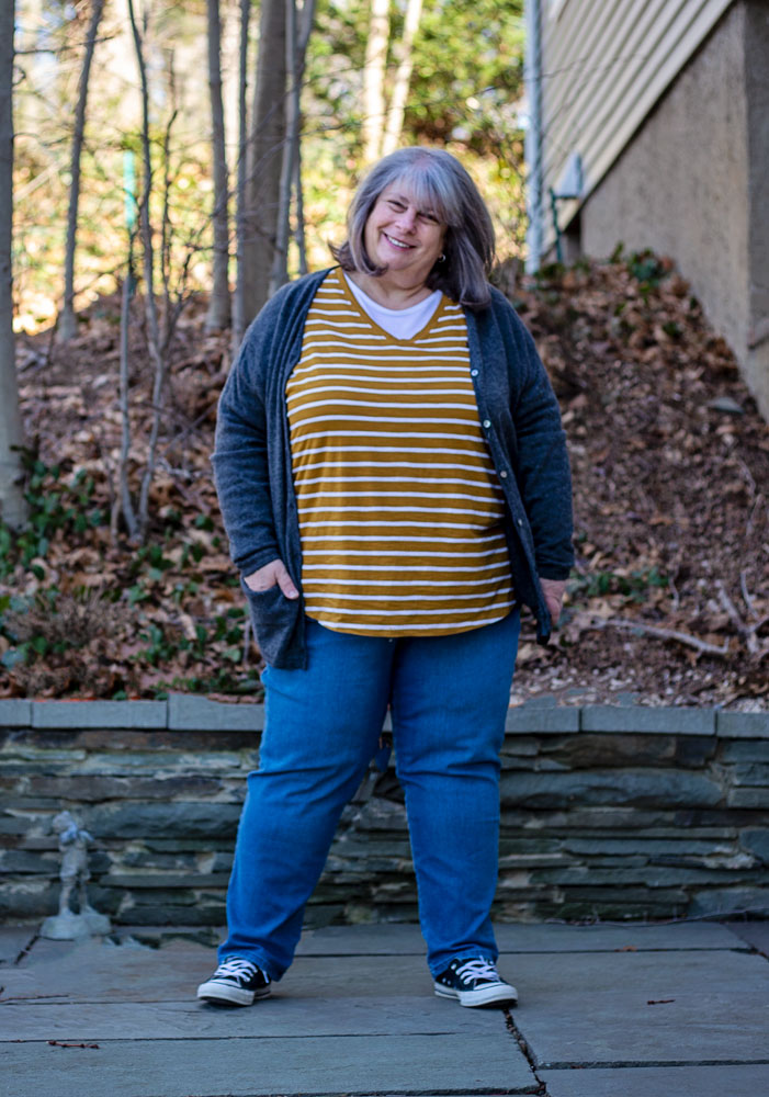bettye standing on patio in striped mustard shirt and grey cardigan