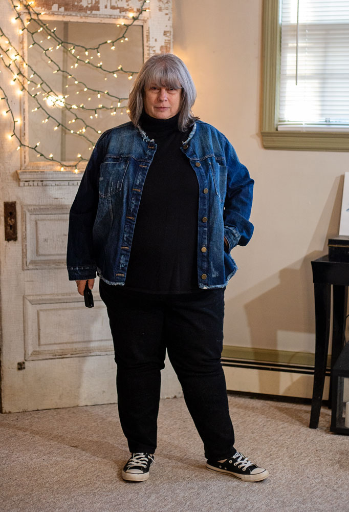 bettye standing in living room in black outfit with denim jacket