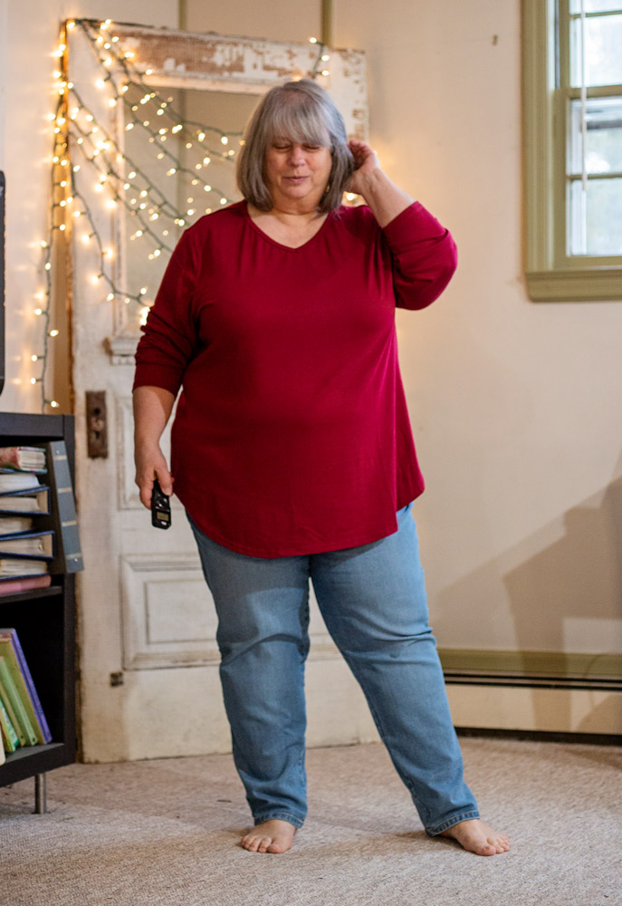 bettye in wine shirt standing inside in front of antique door with twinkle lights
