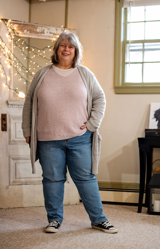bettye in lilac and grey sweaters in front of antique door with twinkle lights