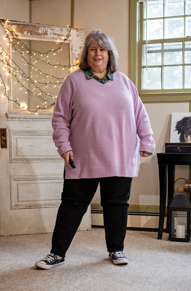 bettye standing in living room wearing a lilac sweater